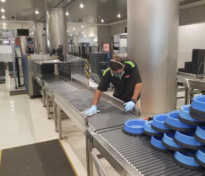A male SERVPRO employee working on a conveyor belt. 